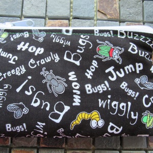 May include: Black fabric pouch with a white zipper and a white drawstring. The pouch has a colorful print of bugs, worms, and the words "Bugs!" "Wiggly" "Jump" "Hop" "Creepy Crawly" and "Buzz".