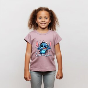 K&ouml;nnte beinhalten: Ein junges M&auml;dchen tr&auml;gt ein mauvefarbenes T-Shirt mit einem Cartoon-Bild von Stitch, der eine Ziegelmauer durchbricht. Stitch ist blau mit gro&szlig;en Ohren und einem verschmitzten Grinsen.