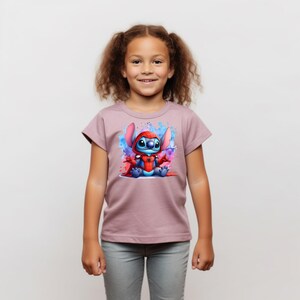 May include: A young girl wearing a mauve t-shirt with a blue cartoon character wearing a red superhero costume. The character is surrounded by colorful watercolor splatters.