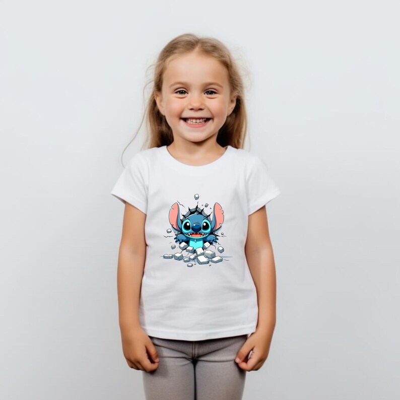 K&ouml;nnte beinhalten: Ein wei&szlig;es T-Shirt mit einer blauen Comicfigur, die durch eine Eiswand bricht. Die Figur hat gro&szlig;e Ohren und einen schelmischen Ausdruck.