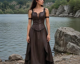 May include: A dark brown floor-length dress featuring a fitted bodice with a lace-up front closure, thin shoulder straps, and arm bands. The skirt has a high-waisted design with side slits that reveal a layered fabric construction.