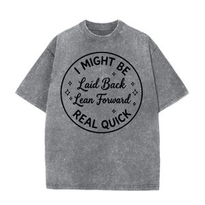Puede incluir: Camiseta gris con cuello redondo y mangas cortas. La camiseta presenta un diseño circular con el texto "I MIGHT BE Laid Back Lean Forward REAL QUICK" en negro. La camiseta tiene un aspecto ligeramente descolorido y vintage.