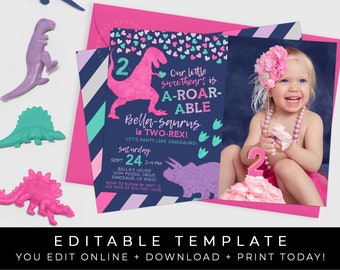 May include: A pink and blue dinosaur-themed birthday invitation for a girl turning two. The invitation features a pink dinosaur silhouette with a glittery pink "2" on its back. The text reads "Our little sweetheart is A-ROAR-ABLE Bella-saurus is TWO-REX! Let's party like dinosaurs!" with a date and time for the party. A photo of a girl in a pink dress with a pink dinosaur cake is in the background.