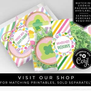 May include: A set of two cookie packaging boxes featuring a rainbow and shamrock design. The boxes are decorated with the text "You're my lucky charm" and "Magically Delicious".