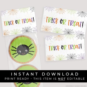 May include: Three printable Halloween treat bag tags featuring a spiderweb pattern and the text "Trick or Treat!" in orange, black, and purple lettering. The tags are designed to be printed and attached to treat bags for Halloween.