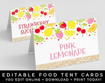 May include: Editable food tent cards with a fruit theme. The cards feature a white background with a gold glitter border. The text on the cards reads "Strawberry Shop" and "Pink Lemonade".