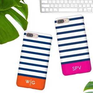 May include: Two iPhone cases with a blue and white striped design. One case has a bright orange bottom with the initials "W/G" in white. The other case has a bright pink bottom with the initials "SPV" in white.