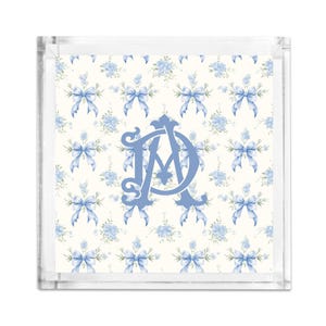 May include: A square, clear acrylic tray with a floral and bow pattern in light blue and white. The center features the intertwined letters "D" and "A" in light blue. The tray is ideal for serving or display.