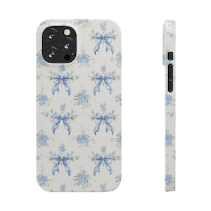 May include: A white phone case with a pattern of blue bows and floral designs.