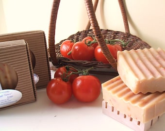 May include: A wicker basket filled with red ripe tomatoes, next to two boxes of handmade soaps labeled "Savons de Nature" with the text "Handmade Soaps".
