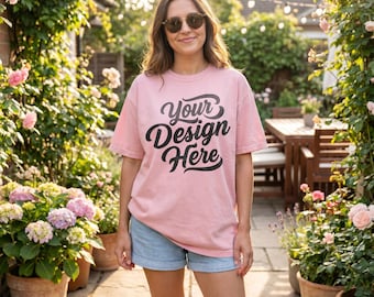 Maqueta de camiseta Blossom Comfort Colors 1717, modelo femenina, estilo de vida veraniego en el jardín, maqueta de camiseta de corte holgado extragrande, color rosa teñido en prenda.