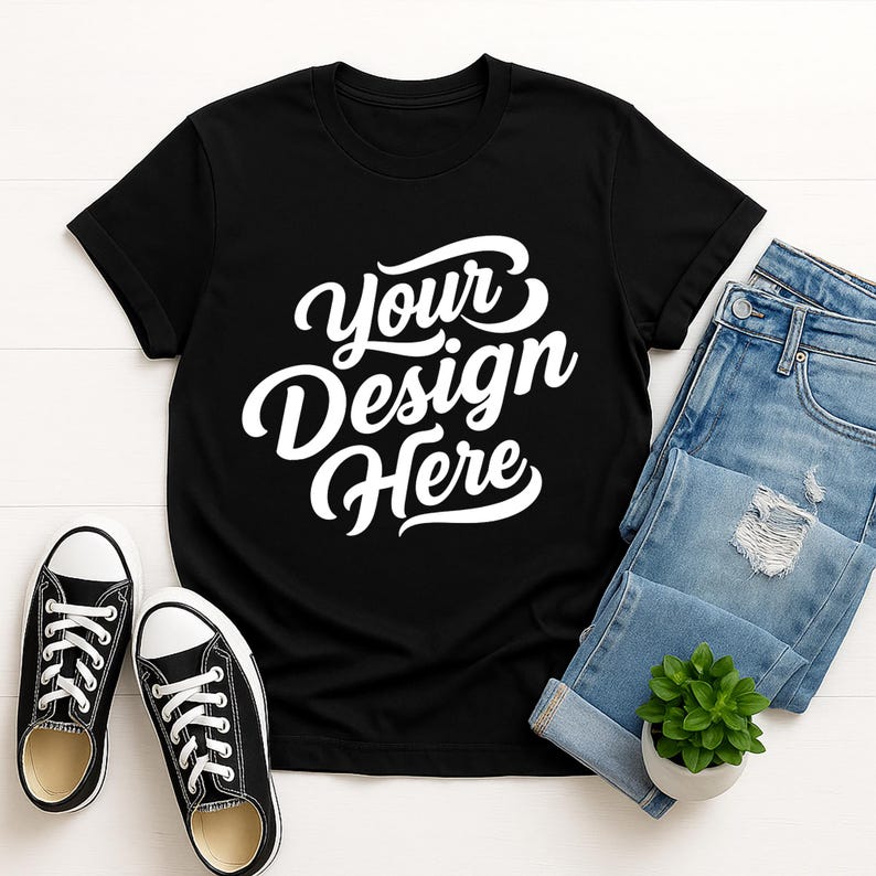 Mockup bundle featuring Gildan 64000 t-shirts in over 70+ colors. The image shows various colored t-shirts with the placeholder text 'Your Design Here' on a flat lay background with flowers, sneakers, and other accessories.