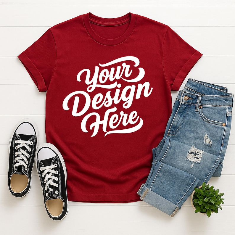Mockup bundle featuring Gildan 64000 t-shirts in over 70+ colors. The image shows various colored t-shirts with the placeholder text 'Your Design Here' on a flat lay background with flowers, sneakers, and other accessories.