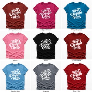 Flatlay display of Gildan 64000 t-shirt mockup bundle in over 50 colors, showcasing various blank shirts including black, red, orange, purple, yellow, green, mint, and pink, each with 'Your Design Here' placeholder text for custom design previews.