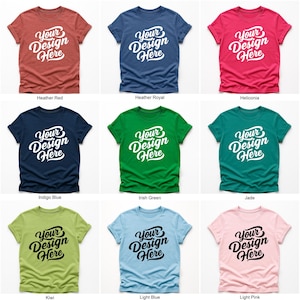 Flatlay display of Gildan 64000 t-shirt mockup bundle in over 50 colors, showcasing various blank shirts including black, red, orange, purple, yellow, green, mint, and pink, each with 'Your Design Here' placeholder text for custom design previews.