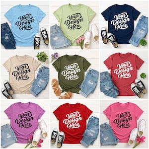 Mockup bundle featuring Gildan 64000 t-shirts in over 70+ colors. The image shows various colored t-shirts with the placeholder text 'Your Design Here' on a flat lay background with flowers, sneakers, and other accessories.