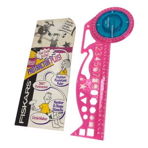 May include: Pink plastic protractor plus tool with a shatter-resistant ruler, 360 degree protractor, circle maker, and number and shape stencils. The packaging shows a cartoon illustration of a person using the tool. The packaging also says "New! Protractor Plus! Four Tools In One!"