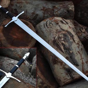 May include: A long, silver sword with a black handle and silver crossguard. The sword is displayed against a backdrop of wooden logs, showcasing its craftsmanship and design. The blade is sharp and the handle is detailed.