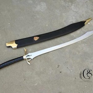 以下が含まれることがあります： 銀色の刃と黒いグリップで包まれた黒い柄の湾曲した剣。 ヒルトとポメルは金色です。 黒い鞘には金色のアクセントと金色のエンブレムが付いています。 剣は灰色の表面に置かれています。