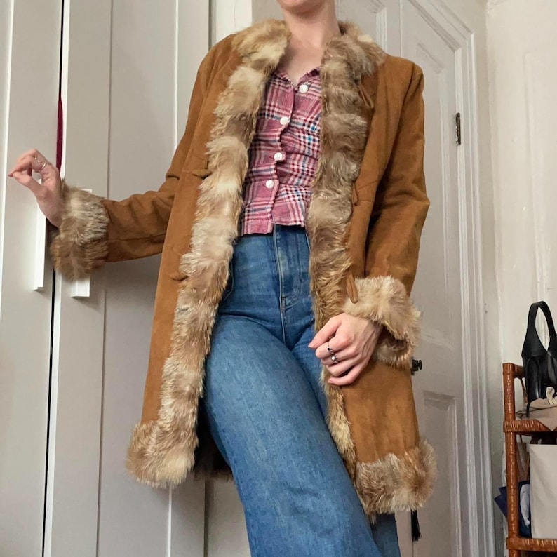 Crafted from premium brown suede, this vintage Penny Lane Coat features soft shaggy fur along the collar, cuffs, and full front trim. Its authentic 70s Afghan-inspired design makes it a standout layering piece for winter. Warm, stylish, and incredibly versatile — ideal for retro outfits, streetwear, or festival looks.