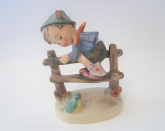 hummel boy on fence with frog