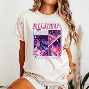 May include: A natural-colored t-shirt featuring the word "RUJINU" in pink and purple, with a graphic of a woman with purple hair. The text "YOU GAVE ME MY SOUL BACK" and "AND NOW, I GIVE IT TO YOU" are also visible.