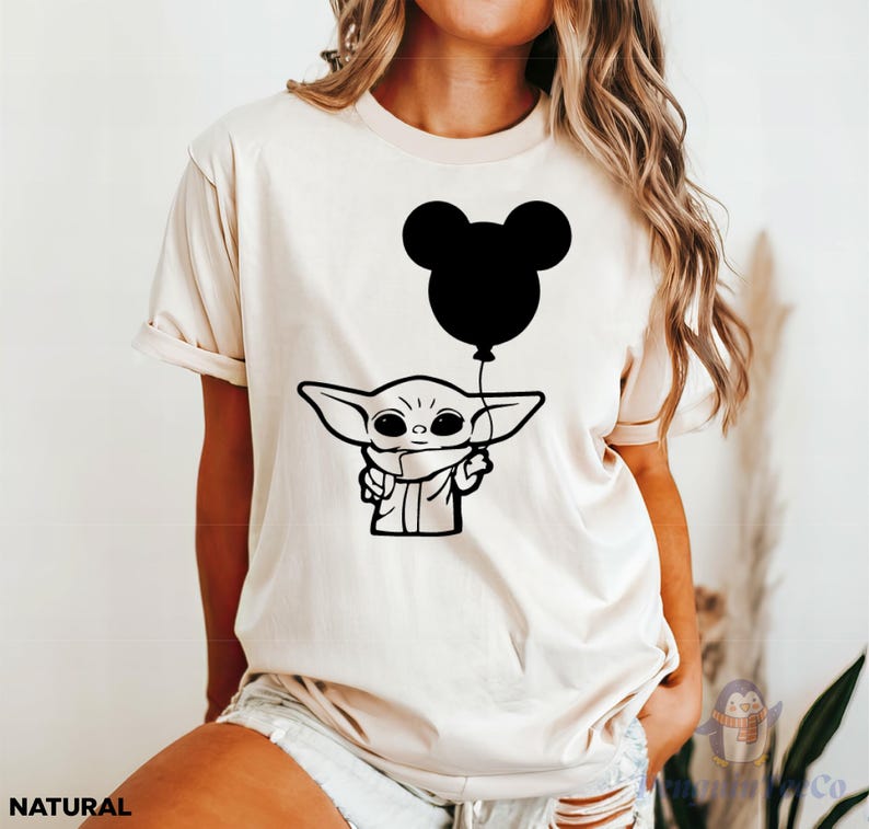 A woman wearing a white t-shirt with a graphic of a young child holding a balloon.