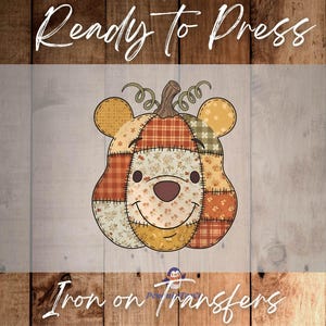 May include: A colorful iron-on transfer featuring a patchwork pumpkin design with bear ears and a smiling face. The pumpkin is made of various patterned fabrics in orange, yellow, and green. The text "Ready to Press" and "Iron on Transfers" are visible.