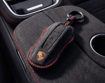 Funda para llave Porsche Alcantara con costuras negras y rojas. Funda personalizada para llaveros 911, Macan, Cayenne, Panamera y Taycan.