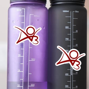 May include: Two water bottles with measurement markings in ounces and milliliters. The bottles are purple and black. Each bottle has a red and white sticker with a stylized figure.