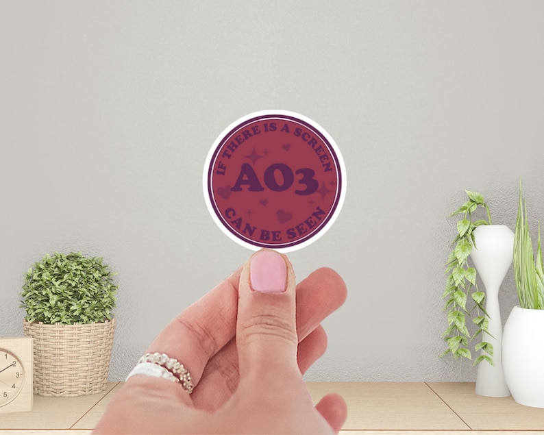 May include: A round sticker with a burgundy background and white text that reads "If there is a screen A03 can be seen". The sticker has a white border and a few small white stars and hearts.