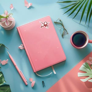 May include: A pink notebook with a red logo on the cover, a pink pen, a pair of glasses, a cup of coffee, and green plants on a blue and pink background.
