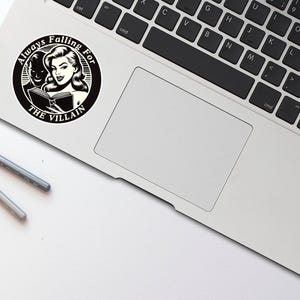 Op de afbeelding: Zwart-witte sticker met een vrouw en een man die een boek lezen. De sticker zegt "Always Falling For The Villain".