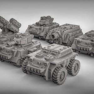 May include: A collection of gray miniature military vehicles, including tanks and armored transports. The vehicles have detailed designs, with turrets, missile launchers, and large wheels. The models are arranged on a light gray surface.