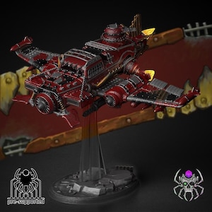 May include: A detailed, red and silver model aeroplane with intricate mechanical details, including propellers and a cockpit. The model is mounted on a clear stand, with a dark background. The text "pre-supported" is visible.