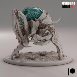 Op de afbeelding: Een gedetailleerde, gebroken witte miniatuur van een wezen met een gesegmenteerd lichaam, stekelige poten en een hoofd dat een turquoise gekleurd brein onthult. De miniatuur staat op een cirkelvormige basis. De tekst "Oshouna Minis" is zichtbaar.