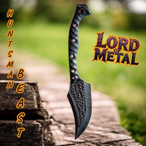 May include: A black metal knife with a textured blade and handle, featuring copper-colored rivets. The image includes the text "LORD OF METAL" and the word "HUNTSMAN BEAST" vertically on the left side.