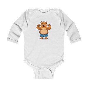 Peut inclure: Body bébé blanc à manches longues avec un ours de dessin animé musclé. L'ours brun a un ventre bronzé et porte un short bleu. Un design amusant et ludique pour les bébés.