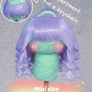 May include: A miniature doll head with lavender curly hair, designed with a compartment for a keychain. The head is mint green and the hair is around the head 5"-5.5".