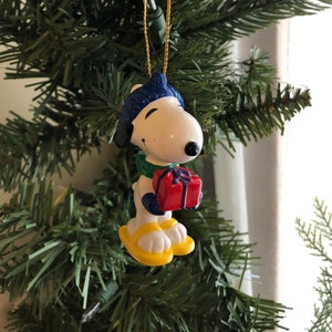 Vintage Snoopy trägt gelbe Schneeschuhe mit Weihnachtsgeschenk-Verzierung