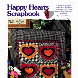 Pode incluir: Uma capa de álbum de recortes com um fundo de tecido xadrez preto e branco. Quatro corações aplicados são dispostos em uma grade. Os corações são vermelhos, laranja e pretos com bolinhas brancas. O título "Happy Hearts Scrapbook" é impresso em letras azuis e brancas no topo da imagem.