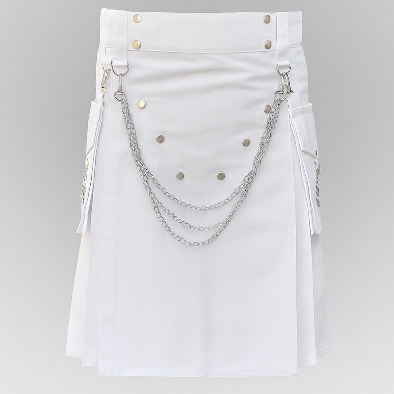 May include: A white kilt with silver chain detailing and pockets. The kilt features silver rivets and metal hardware. The design includes a pleated front and a chain that hangs across the front. The kilt is made of a smooth, solid white material.