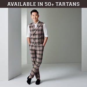 May include: A man wearing a three-piece plaid suit in shades of brown, black, and pink. The suit includes a double-breasted vest, matching trousers, and a white dress shirt. The text "AVAILABLE IN 50+ TARTANS" is at the top of the image.