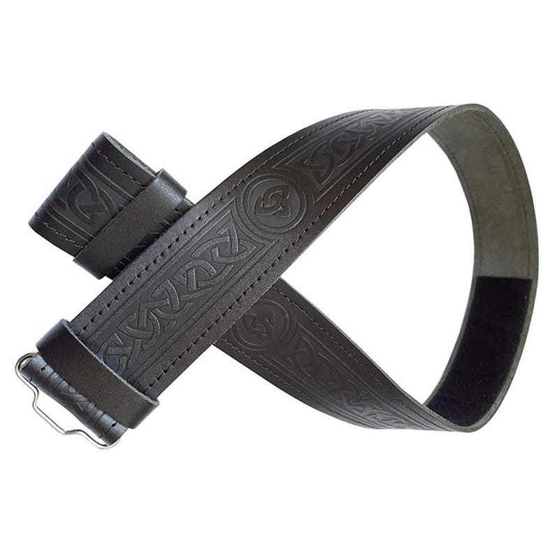 May include: A black leather belt with an embossed Celtic knot design. The belt features a buckle and a Velcro closure. The intricate pattern covers the entire length of the belt, showcasing a traditional style.