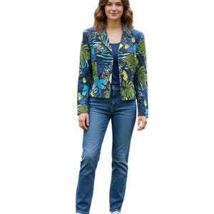 May include: A woman wearing a blue blazer with a green and blue tropical leaf print, paired with blue jeans and a blue top. The blazer has a collared neckline and long sleeves. The jeans are a classic straight-leg style.