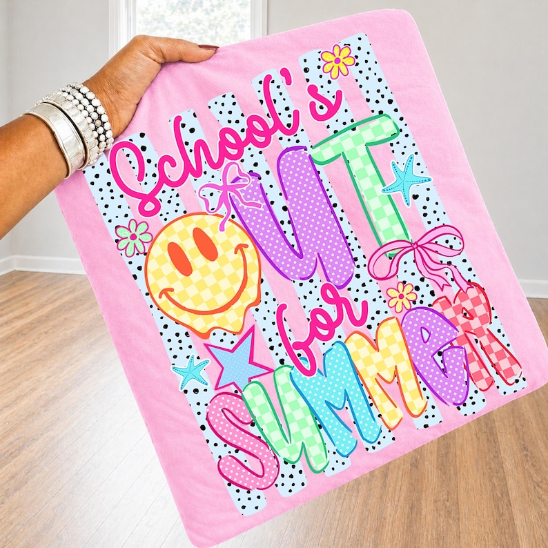 Puede incluir: Manta rosa con las palabras "School's Out for Summer" en letras coloridas y juguetonas. El dise&ntilde;o incluye una carita sonriente, estrellas, flores y lazos. La manta tiene un fondo a rayas y lunares.
