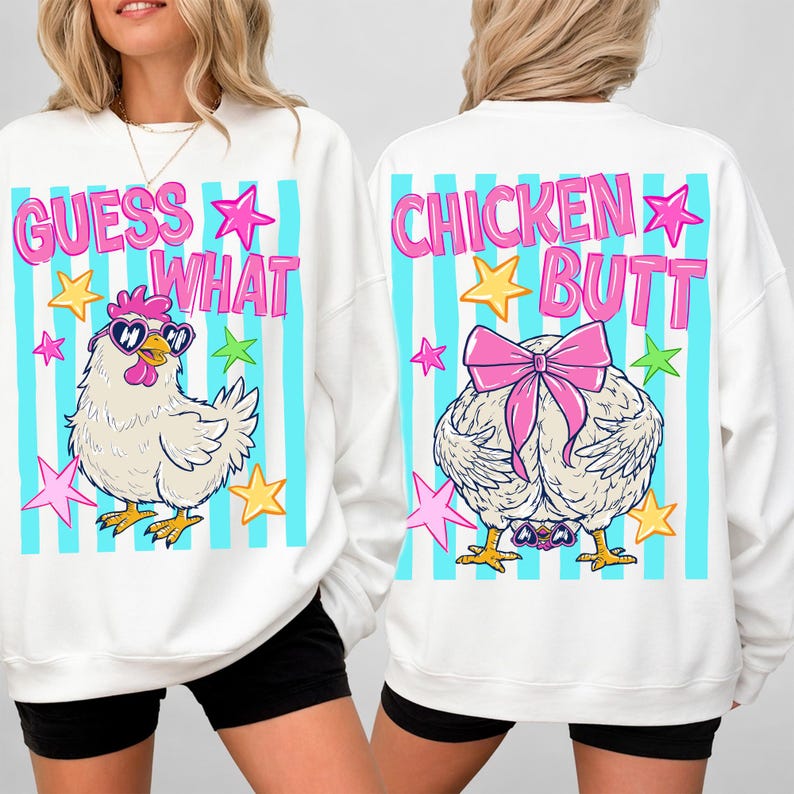 May include: White sweatshirt with a cartoon chicken design. The front says "GUESS WHAT" with a chicken wearing sunglasses. The back says "CHICKEN BUTT" with a chicken's rear and a pink bow. Blue and white striped background.