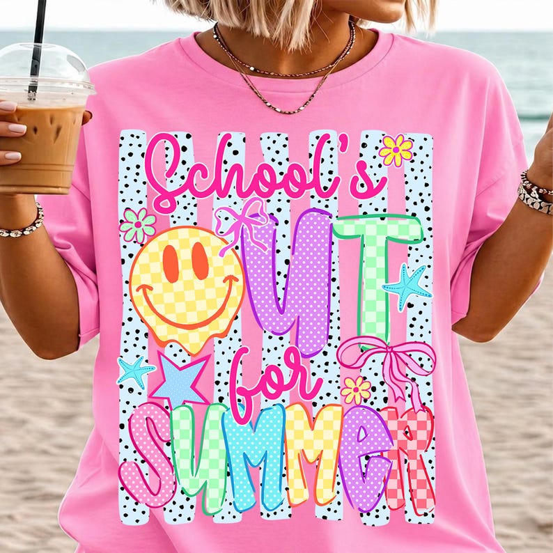 Puede incluir: Camiseta rosa con la frase "School's Out for Summer" en letras coloridas y divertidas. El dise&ntilde;o incluye una carita sonriente a cuadros, estrellas, flores y lazos, creando un ambiente veraniego y divertido. La camiseta tiene un corte holgado.