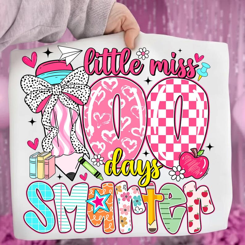 May include: A white tote bag featuring a colorful design celebrating 100 days of school. The design includes the words "little miss 100 days smarter" with hearts, flowers, and an apple.