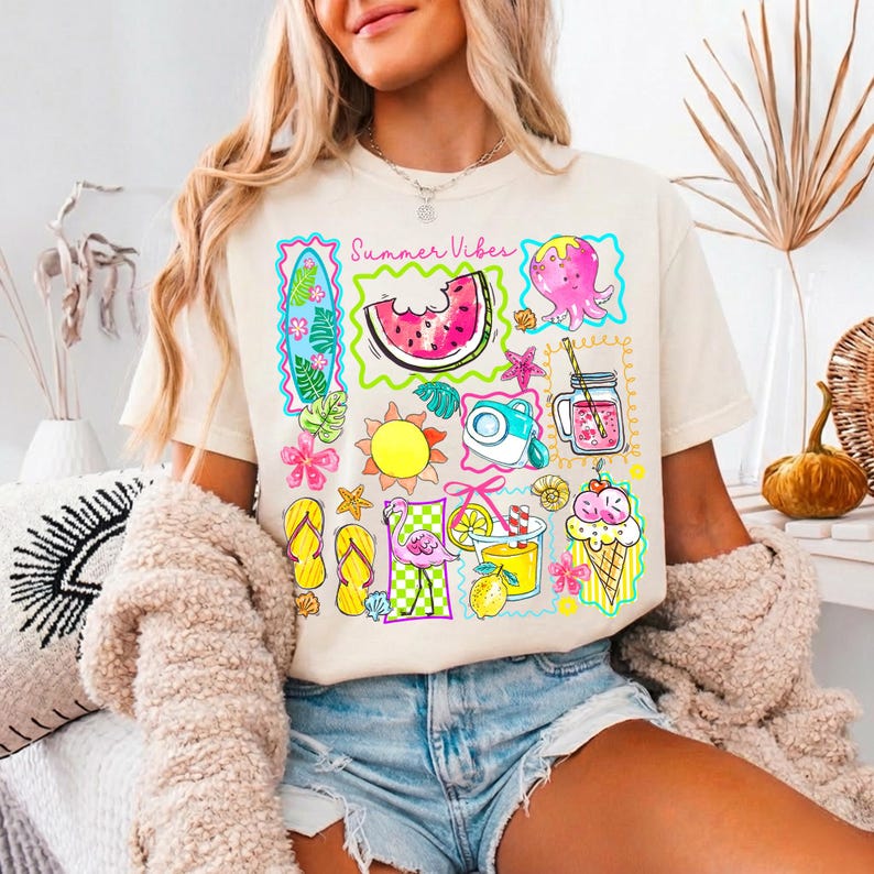 Puede incluir: Camiseta color crema con un gr&aacute;fico colorido de tem&aacute;tica veraniega. El dise&ntilde;o incluye una rodaja de sand&iacute;a, sol, c&aacute;mara, pulpo, cono de helado y el texto "Summer Vibes". La camiseta se combina con pantalones cortos vaqueros.